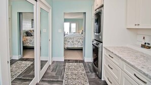 A modern kitchen with white cabinets, a granite countertop, and a built-in oven. - Dark and Stormy, Almost Oceanfront House in Emerald Isle, NC! (Emerald Isle)