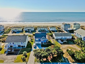 Una zona residencial costera con casas, una playa y una vista despejada del océano.