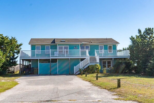 A two-story building with a balcony and a covered entrance. - Decks Ahoy, Oceanfront House in Emerald Isle, NC! (Emerald Isle)