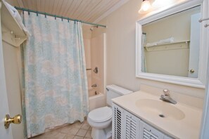 A bathroom with a shower, toilet, sink, and a mirror. - Decks Ahoy, Oceanfront House in Emerald Isle, NC! (Emerald Isle)
