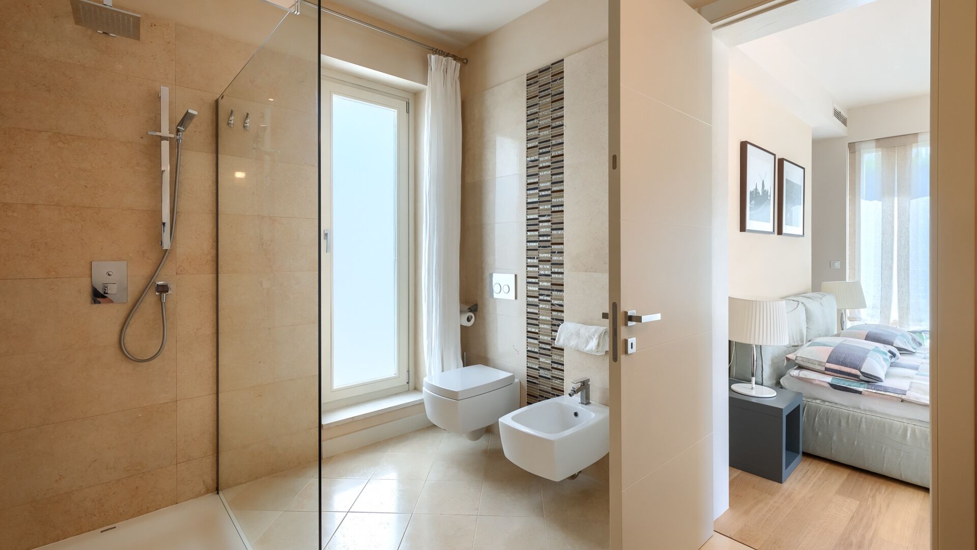 Une salle de bain moderne avec une douche à parois de verre, des toilettes, un bidet et un lavabo.