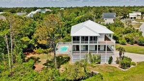 Une maison à deux étages dotée d’un grand balcon et d’une piscine.