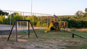 A playground with a swing set, slide, and climbing structure.
