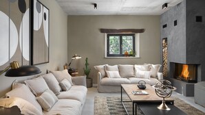 A modern living room with a fireplace, a sofa set, a coffee table, and a bookshelf.