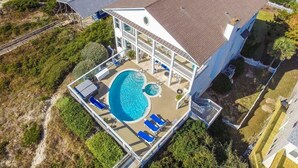 A large house with a swimming pool, a covered deck, and a fenced yard. - Gone With The Waves, Oceanfront House in Emerald Isle, NC! (Emerald Isle)