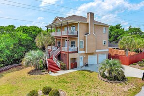 A two-story house with a front porch, a staircase, and a garage.
