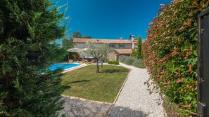 A villa with a swimming pool, stone pathway, and lush greenery. - Villa Nonni by Villas Guide (Cerion)