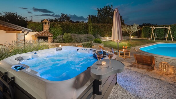 A hot tub with a control panel, a pool, and outdoor furniture. - Villa Nonni by Villas Guide (Cerion)