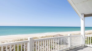 A beach view from a covered porch with white railings. - Grandview, Oceanfront House in Emerald Isle, NC! (Emerald Isle)