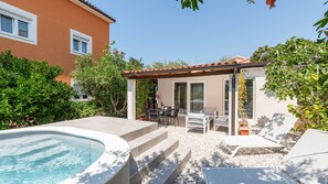 Un jardin avec une piscine, un espace salon extérieur et une pergola.