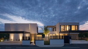 Una casa moderna de dos pisos con techo plano, ventanas amplias y diseño minimalista.