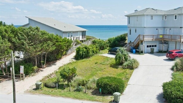 A coastal property with two white buildings, a driveway, and a view of the ocean. - Tranquillis East, Almost Oceanfront Duplex in Emerald Isle, NC! (Emerald Isle)