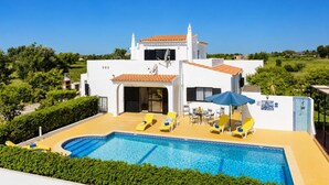 A white villa with a swimming pool, outdoor seating, and a view of the countryside. - Casa Das Areias - Three Bedroom Villa, Sleeps 6 (Porches)