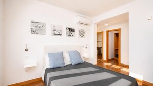 Een moderne slaapkamer met een bed, nachtkastjes en kunst aan de muur.