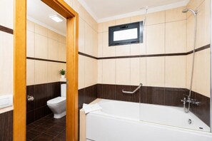 A bathroom with a bathtub, toilet, and shower.