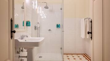 A bathroom with a white sink, a glass-enclosed shower, and a tiled floor with a diamond pattern.
