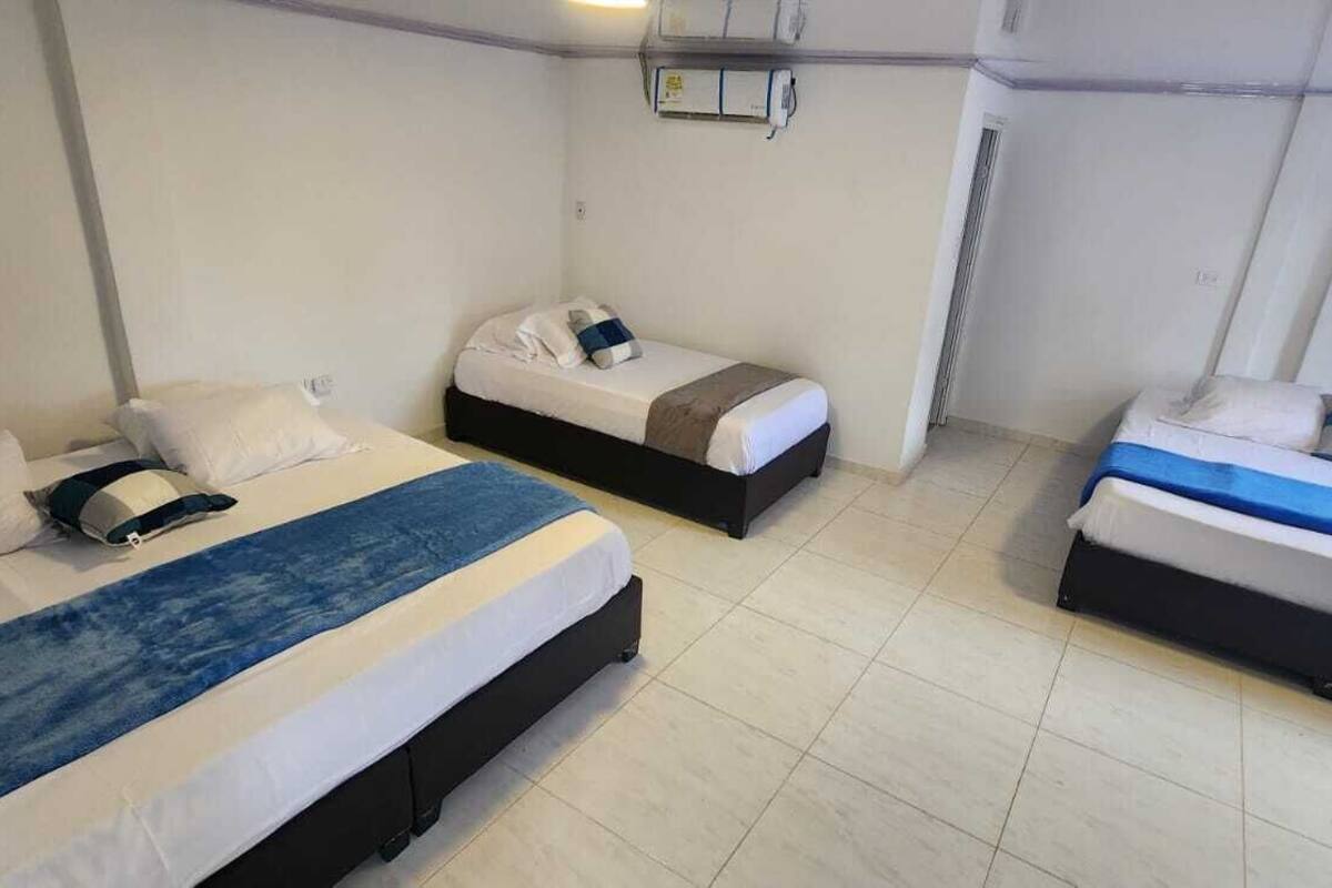 Ein Hotelzimmer mit zwei Einzelbetten, jeweils mit Kissen und Decke.