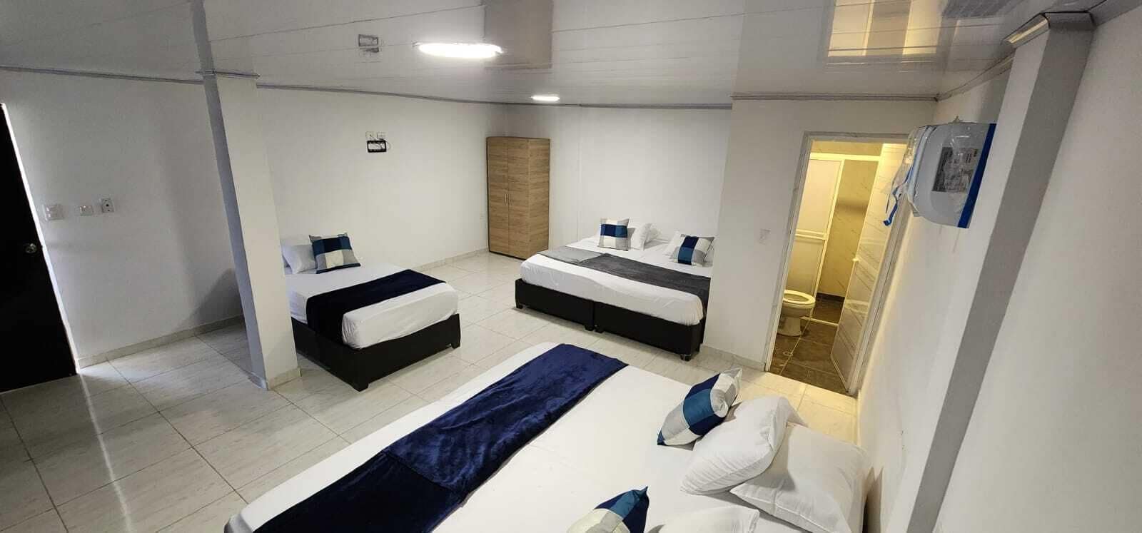 Una habitación de hotel con dos camas, un armario y baño.