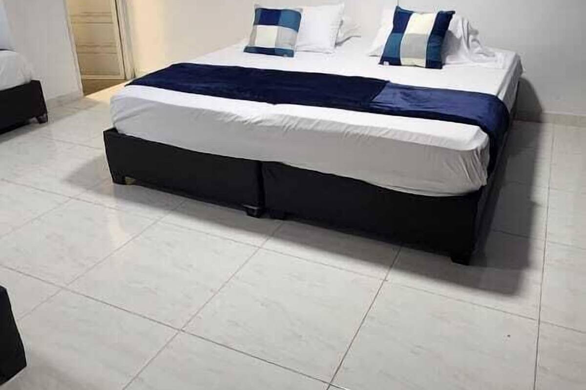 Ein Schlafzimmer mit einem großen Bett, einem Kleiderschrank und einer Deckenleuchte.
