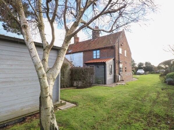 A two-story house with a red-tiled roof, a garage, and a well-maintained lawn. - Lanthorn Cottage (Norwich)