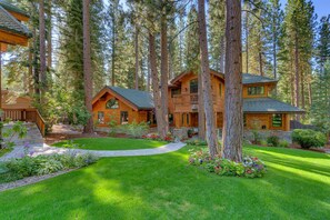 A cabin-style house surrounded by tall trees, with a well-maintained lawn and a stone pathway leading to the entrance. - Mill Creek Retreat - Incline Village - TLUXP (Incline Village)