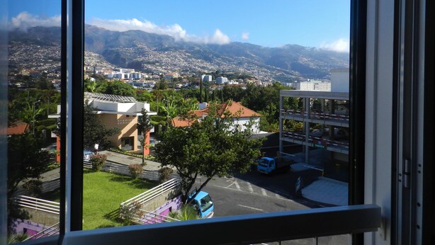 A view from a window overlooking a cityscape with mountains in the background. - Christmas and New Year´s Eve in Madeira Island, Portugal (Funchal)