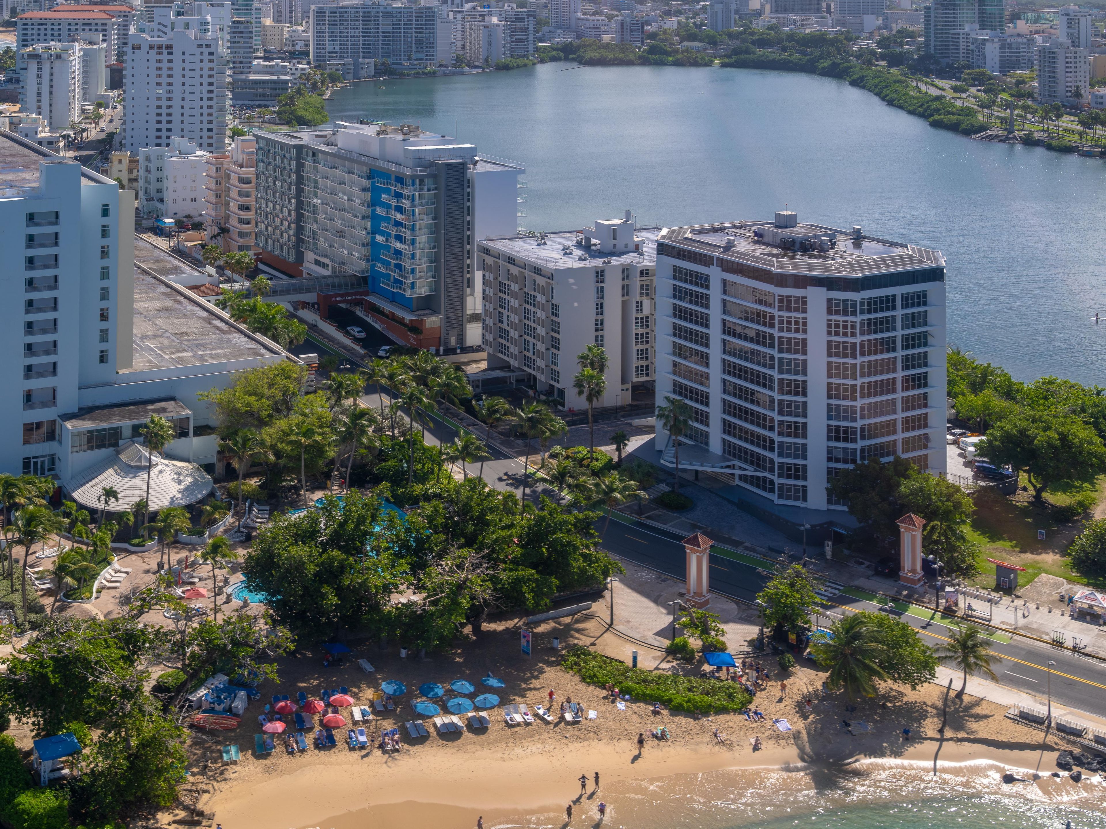A high-rise hotel with a pool area and beach access.