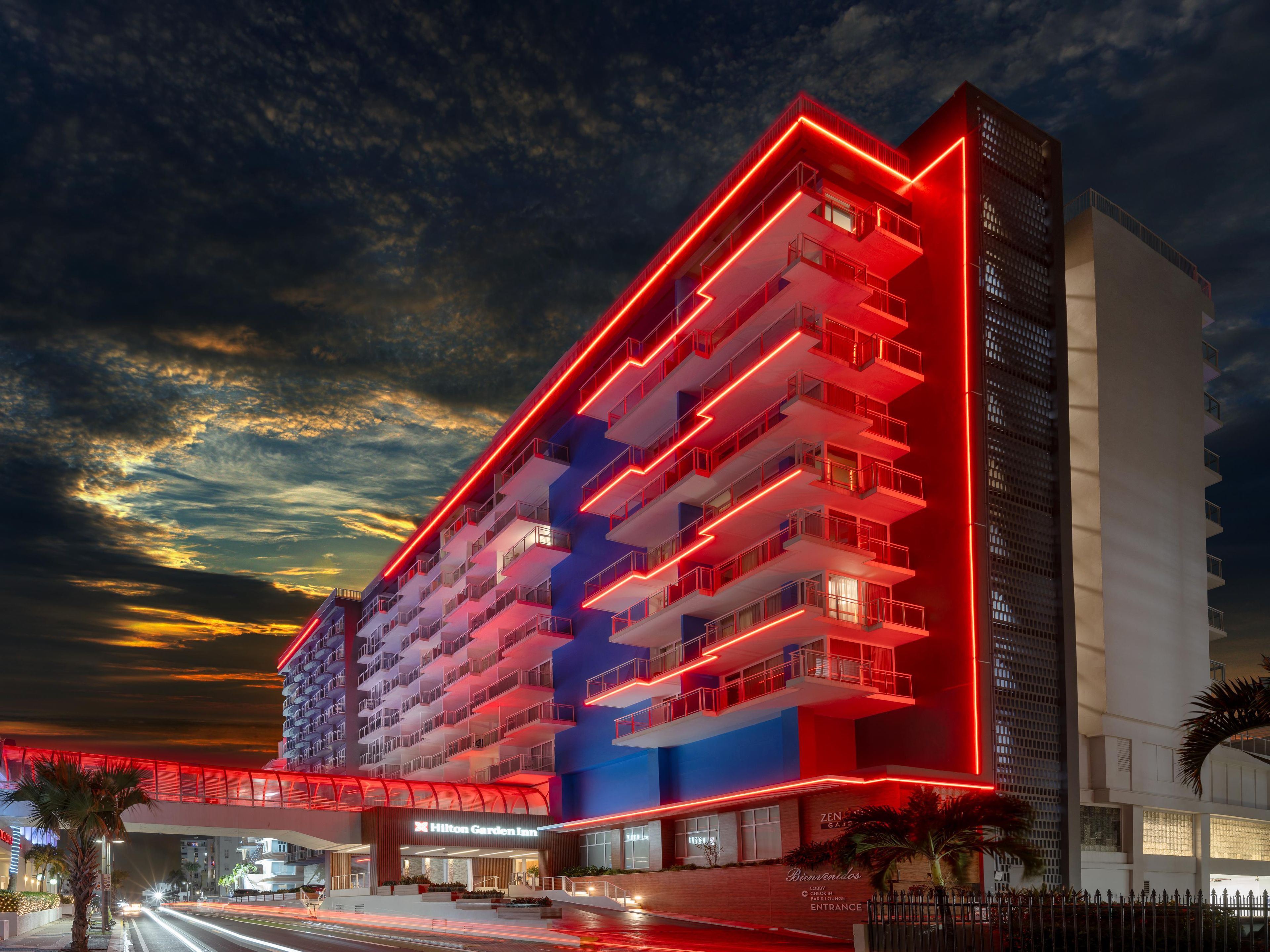 Un hotel de varios pisos con diseño moderno, que cuenta con balcones y una entrada destacada.