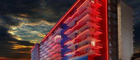 A multi-story hotel with a modern design, featuring balconies and a prominent entrance.