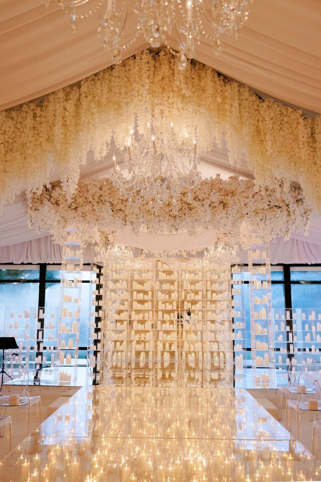 Un espacio interior con candelabro, decoración floral y exhibición de productos en estanterías.