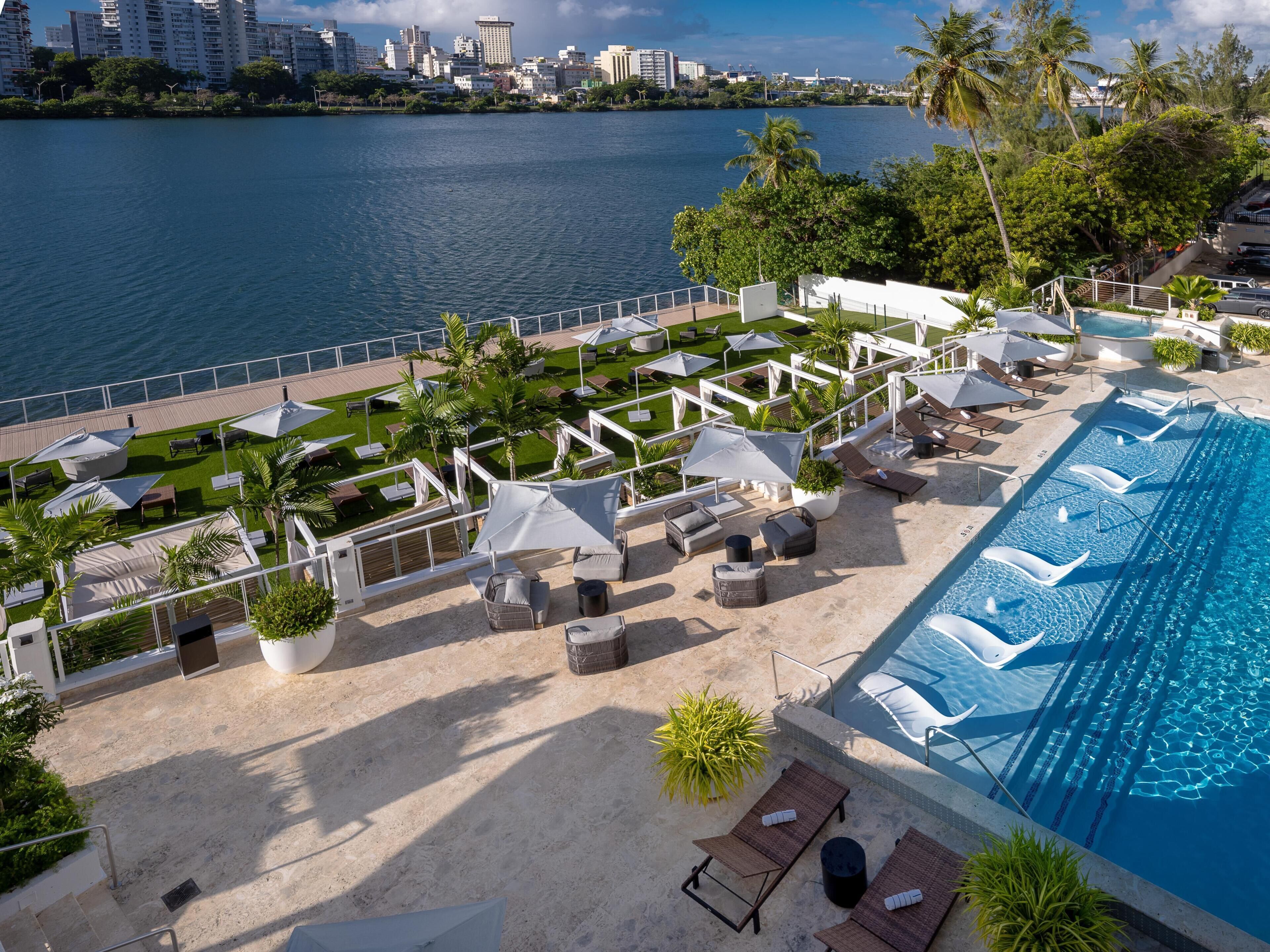 Una piscina al aire libre, sombrillas, tumbonas