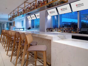 A bar area with multiple seating options and a variety of liquor bottles.