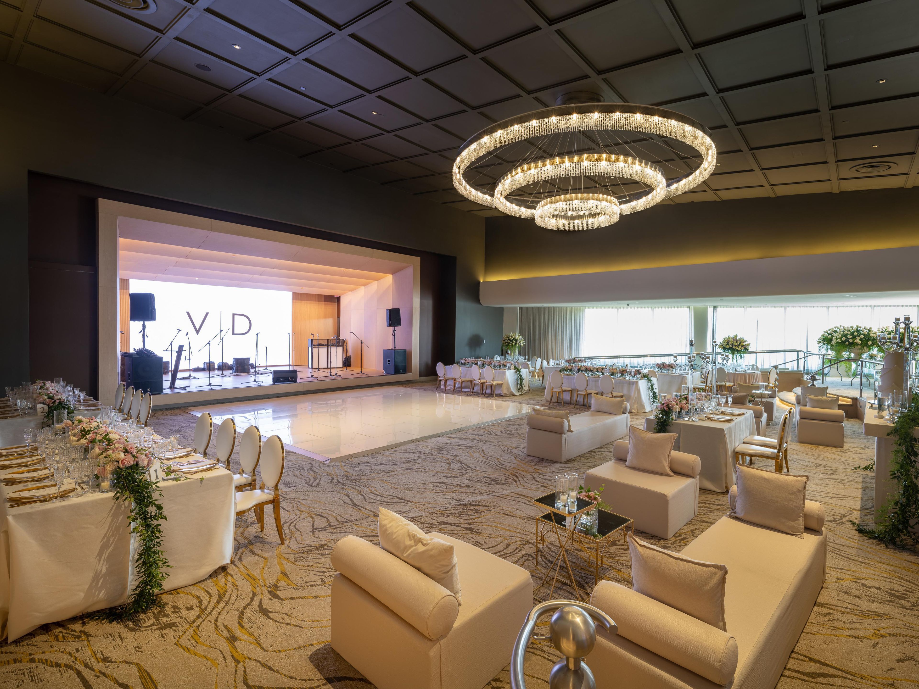 A spacious hall with tiered seating, a stage with musical instruments, and a chandelier.