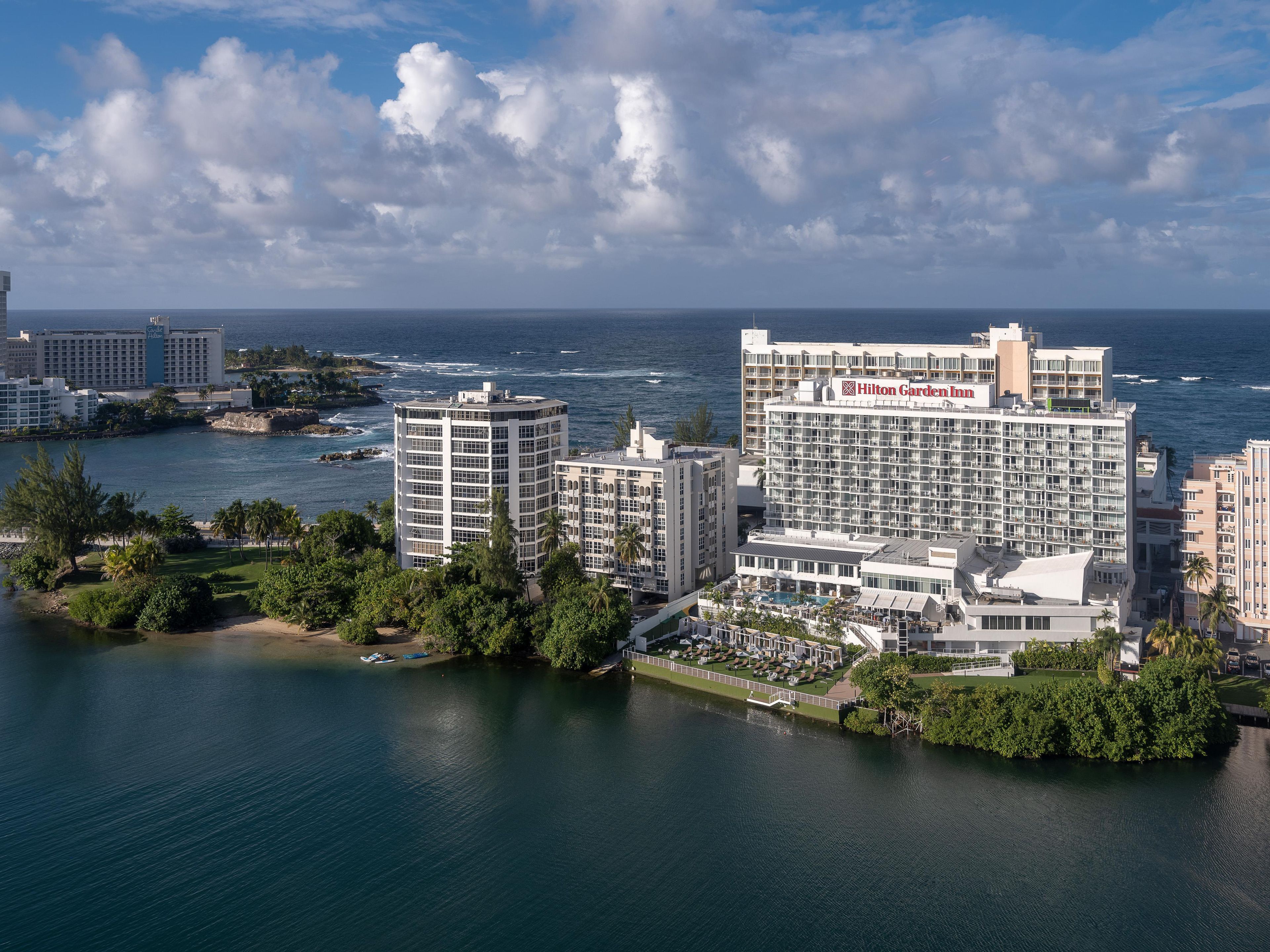 A coastal hotel with multiple buildings, a beachfront, and a view of the ocean.