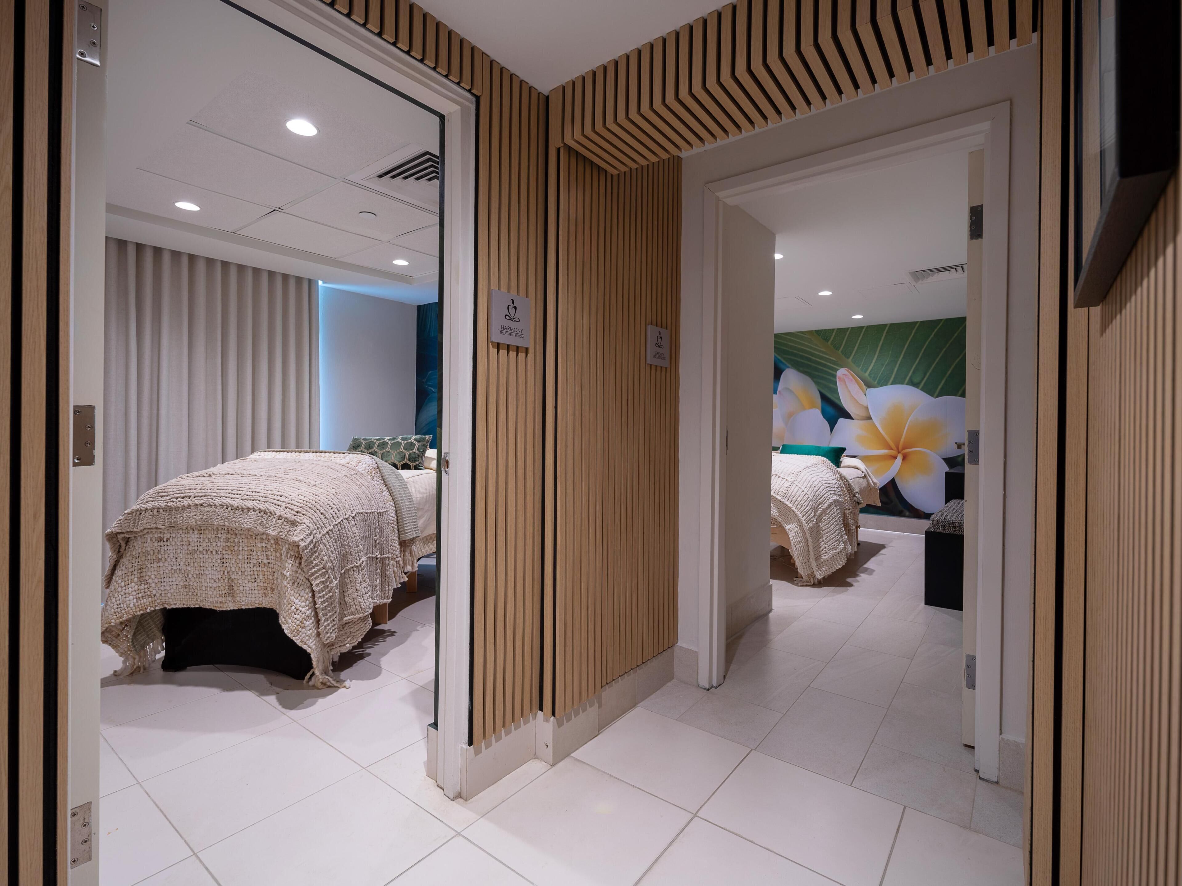 Una habitación de hotel con cama, baño y un amplio mural floral.