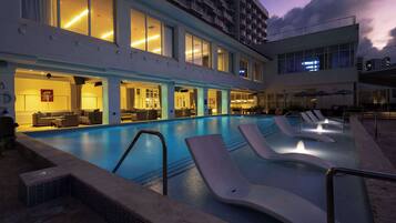 Una piscina al aire libre, sombrillas, tumbonas