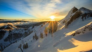 Un paysage de montagne enneigé, avec un télésiège et un ciel dégagé.