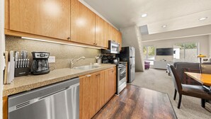 A modern kitchen with wooden cabinets, stainless steel appliances, and a dishwasher. - 354 | Premium Loft Vibes - Oven, A/C + Pool (Olympic Valley)