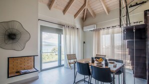 A dining area with a table, chairs, and a view of the outdoors. - Blue Symphony Suites & Apartments (Lefkada)