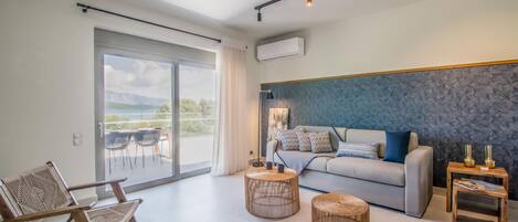 A modern living room with a sofa, two round wicker side tables, a chair, and a large sliding glass door leading to an outdoor balcony.