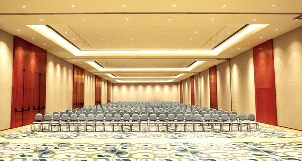 A conference room with rows of chairs, a patterned carpet, and recessed lighting. - Hilton Mendoza (Guaymallen)