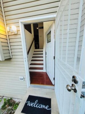 A house entrance with a wooden staircase leading to the interior.