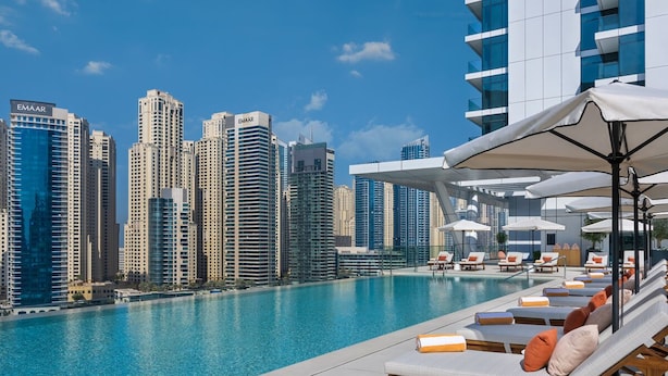 A rooftop pool with lounge chairs and umbrellas, overlooking a cityscape with high-rise buildings. - Vida Residences Dubai Marina (Dubai)