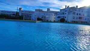 En swimmingpool med udsigt til moderne bygninger i baggrunden.