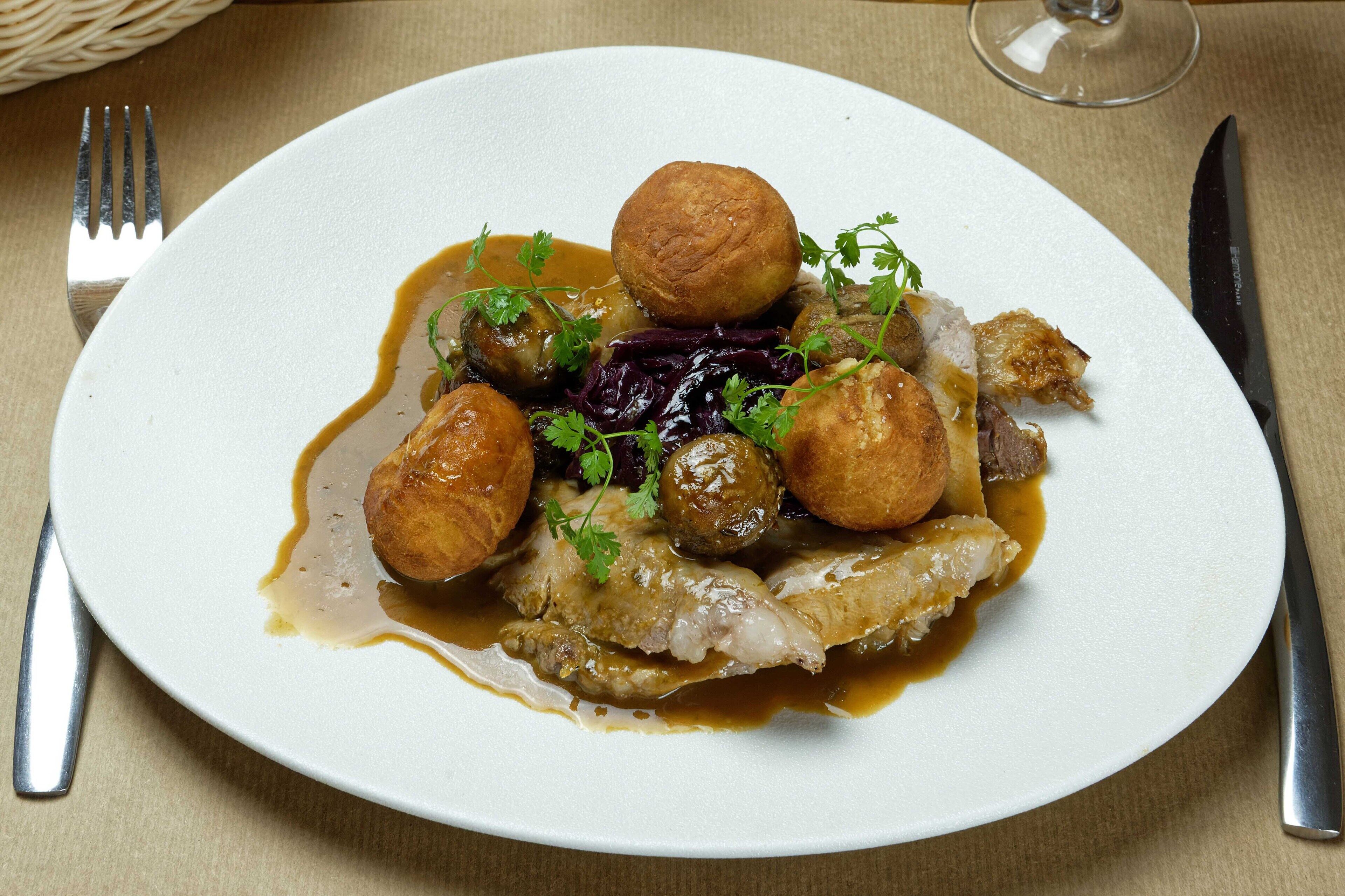 A plate of food with meat, potatoes, and sauce.