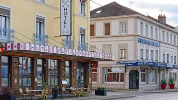A hotel with outdoor seating and a sign indicating it is a restaurant.