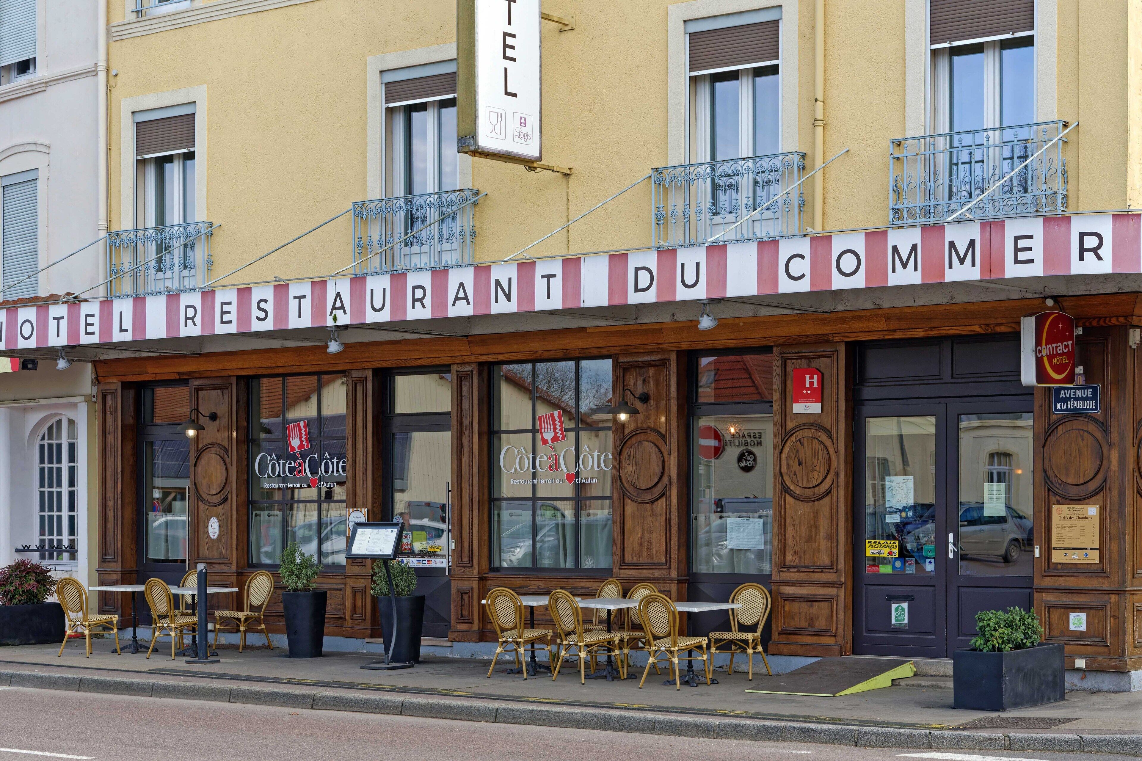 A hotel with outdoor seating and a sign reading "HOTEL RESTAURANT DU COMMER".