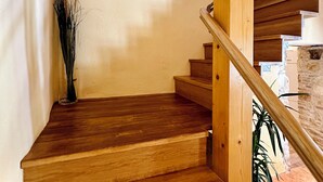 A wooden staircase with a white wall and a framed picture above it.