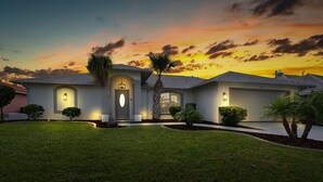 Une maison de plain-pied avec une entrée à l’avant, un garage et une pelouse bien entretenue.