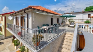 A two-story building with a balcony, outdoor seating, and a pool area. - Studio with a large terrace (Novi Vinodolski)